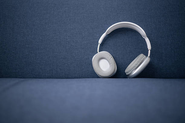White and gray wireless headphones on a blue sofa, ready to deliver powerful